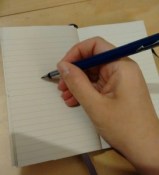A hand, writing with a fountain pen