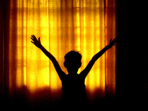 boy in shadows leaping for joy
