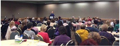 Photo of Lev Raphael speaking to a room of 100 people in 2014