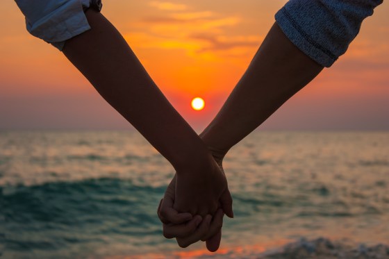 Couple Holding Hands at Sea Sunset